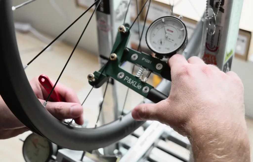 Vérification des tensions avec outils professionnel de montage de roues sur mesures 